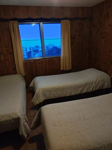 a room with two beds and a window with a view at Hotel Panoramico Bariloche in San Carlos de Bariloche