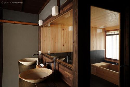 a bathroom with two sinks and two tubs at NIPPONIA HARIMA FUKUSAKI ZOUSHONO YAKATA in Fukusaki