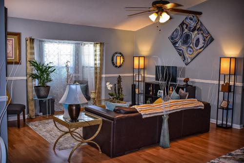 Una sala de estar con un sofá y un ventilador de techo. en Welcome to the Cottage: A Home Away from Home, en Port Saint Lucie