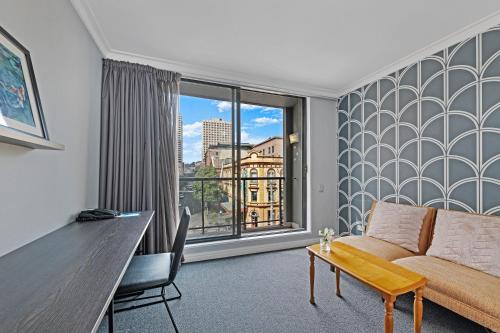 a living room with a couch and a large window at KozyGuru | Sydney CBD | Freshly | 2 Bed Studio in Sydney