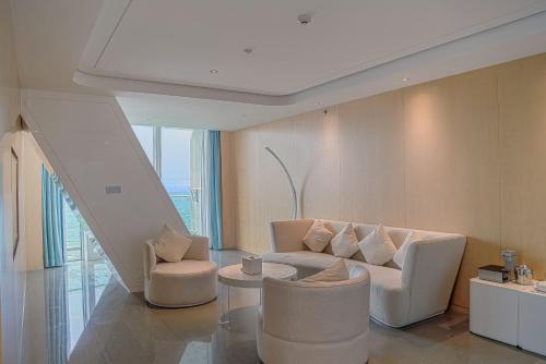 a living room with a couch and two chairs at The Mangrovetree Sanya Resort in Sanya