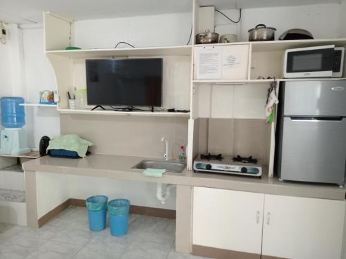 a kitchen with a counter with a sink and a microwave at Okoy Guest House in Bantayan Island