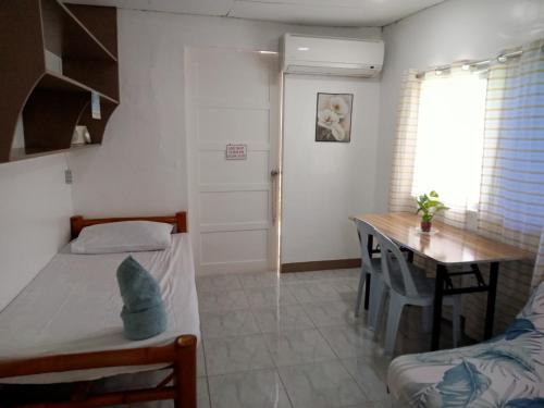 a bedroom with a table and a bed and a desk at Okoy Guest House in Bantayan Island