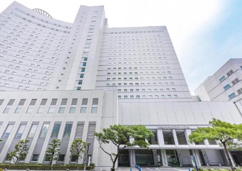 a large white building with trees in front of it at Tokyo Bay Ariake Washington Hotel in Tokyo