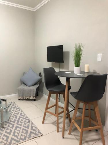 a dining room with a table and two chairs at Meridian Suite Apartments in Umhlanga Ridge in Durban