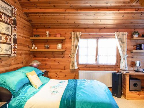 Mattishall的住宿－Cabin Hideaways, Glengoyne - Uk38363，木制客房内的一间卧室,配有一张床