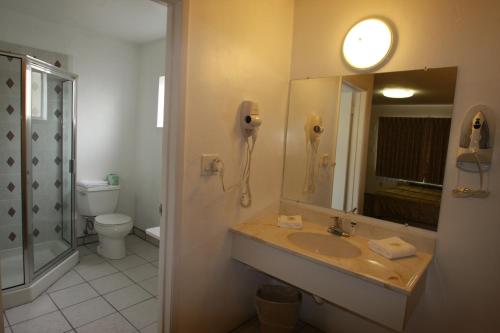 a bathroom with a sink and a mirror and a phone at Redwood Inn in Santa Rosa