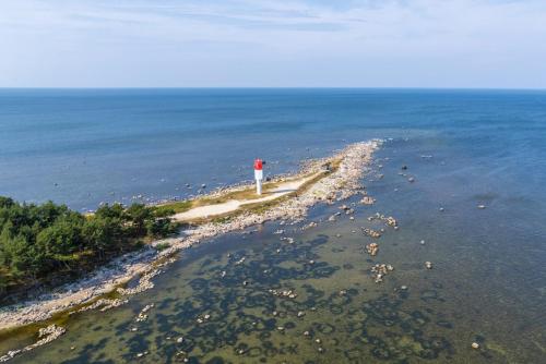 una isla con un faro rojo en el agua en Saunaga puhkemaja Spithamis, 250 meetrit merest!, en Spithami