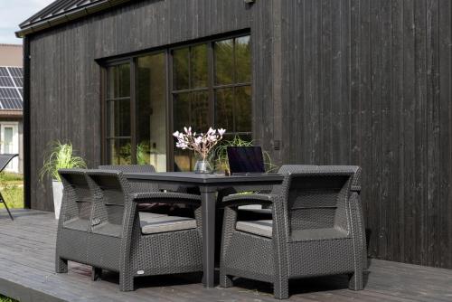 a table with two chairs and a laptop on a patio at Saunaga puhkemaja Spithamis, 250 meetrit merest! in Spithami