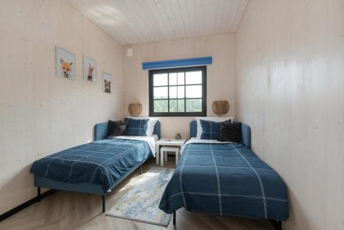 a room with two beds and a window at Saunaga puhkemaja Spithamis, 250 meetrit merest! in Spithami