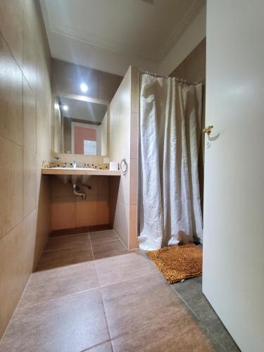 y baño con ducha, lavabo y espejo. en Casa Azcuénaga - Parque - Zona comercial - Aerop 15 min en Monte Grande
