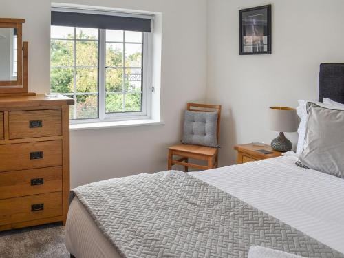 1 dormitorio con 1 cama, vestidor y ventana en Old Road Cottage, en Conwy
