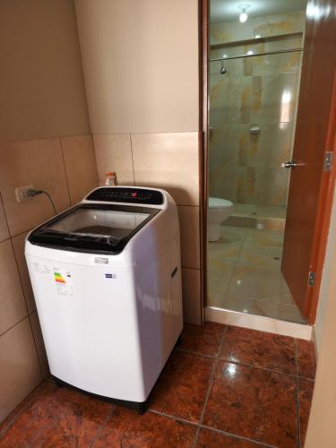 eine Waschmaschine und einen Trockner im Bad mit Dusche in der Unterkunft Departamento Amoblado Arequipa in Arequipa