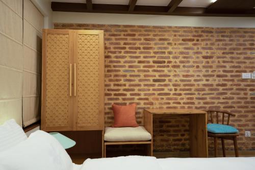 a room with two chairs and a brick wall at Karuna Hotel Patan Kathmandu in Pātan