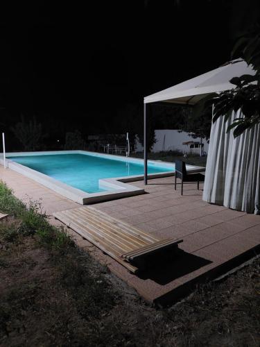 una piscina por la noche con una mesa y una sombrilla en JRVEZH H&L- live and work, en Jrvezh