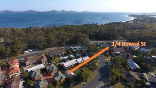 an aerial view of a house with the ocean in the background at 1 - 4 Bowral St Hawks Nest in Hawks Nest