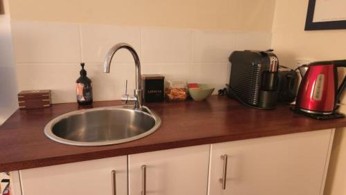 eine Küchentheke mit einer Spüle und einer Mikrowelle in der Unterkunft Chez Vous Split Level Balcony Spa Villa 1 in Pokolbin