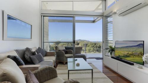 un salon avec un canapé et une télévision dans l'établissement Unit 12 Beaches, à Hawks Nest