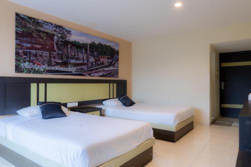 a hotel room with two beds and a tv at Hotel Sampurna Jaya in Tanjung Pinang 