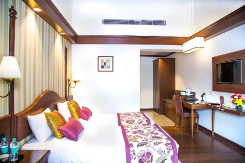 a hotel room with a bed and a desk at Shervani Hilltop Resort in Nainital