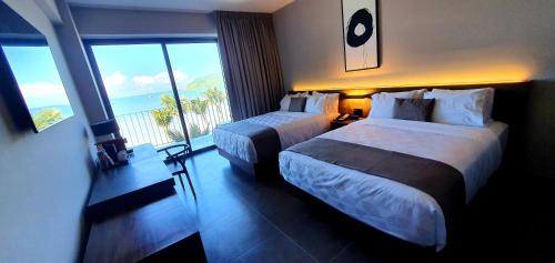 a hotel room with two beds and a large window at Viaggio Resort Mazatlán in Mazatlán