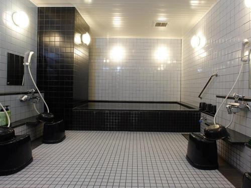 a bathroom with a bath tub and two toilets at Hotel Aston Hotel Osaka Sakai in Sakai