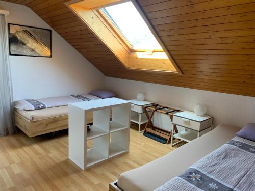 Zimmer im Dachgeschoss mit 2 Betten und einem Dachfenster in der Unterkunft Pension Chalet Charme in Siebnen