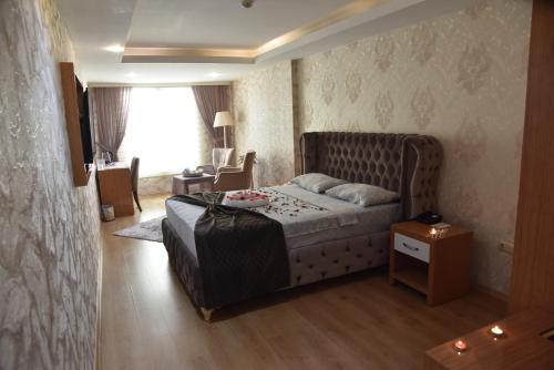 a bedroom with a bed and a table and a window at Bayazıt Hotel in İskenderun