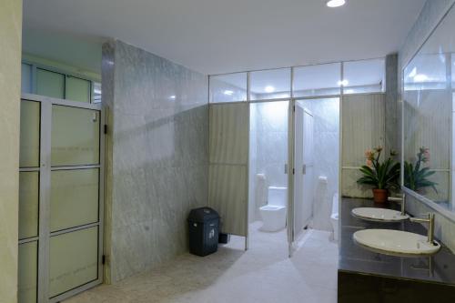 a bathroom with two sinks and a toilet at Hotel Sampurna Jaya in Tanjung Pinang 