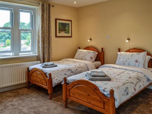 een slaapkamer met 2 bedden en een raam bij Town Foot Farm in Newby
