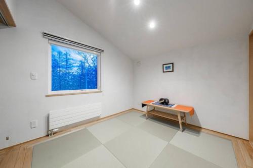 Habitación blanca con mesa y ventana en 6ty6 Vacation Home, en Niseko