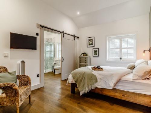 a bedroom with a large bed and a television at Walnut Tree Barn in Thetford