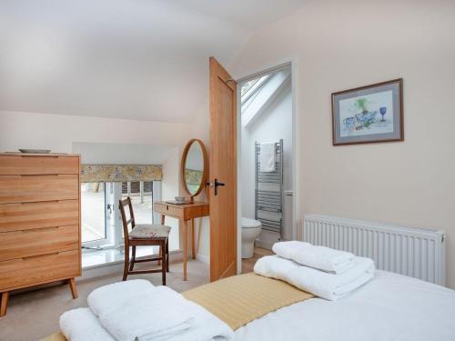 a bedroom with a bed and a desk and a mirror at Upper Red Down - Uk37699 in Witheridge