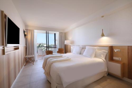 a hotel room with a large bed and a large window at Iberostar Selection Anthelia in Adeje