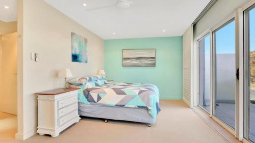 a bedroom with a bed and a window at 1 - 58 Moira Pde, Hawks Nest in Hawks Nest