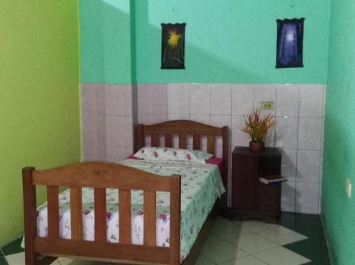 a bedroom with a bed and a green wall at Casa Mafaldo in Iquitos