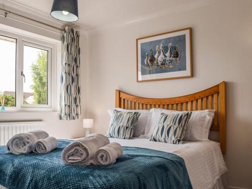 a bedroom with a bed with towels on it at Paradise House in Honington