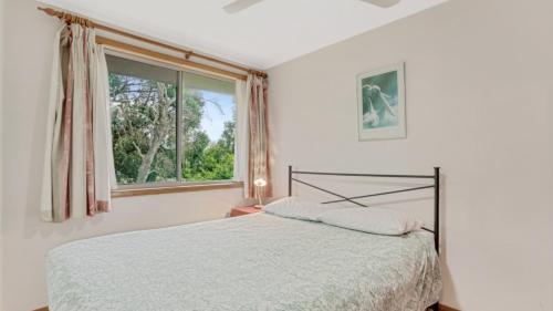 a bedroom with a bed and a window at 4 Kururma Crescent Hawks Nest in Hawks Nest