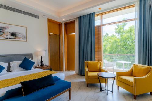 a hotel room with a bed and two chairs at ELLAA RESIDENCES in Hyderabad