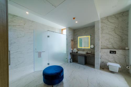 a bathroom with a blue stool and a sink at ELLAA RESIDENCES in Hyderabad