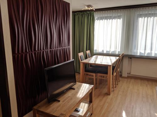 a living room with a television and a dining room table at Ferienwohnung Alpenblick in Davos