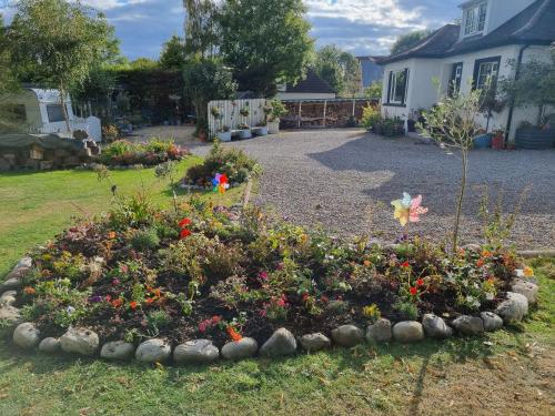 a garden with a flower bed in the yard at Nannys tiny hoose in Inverness