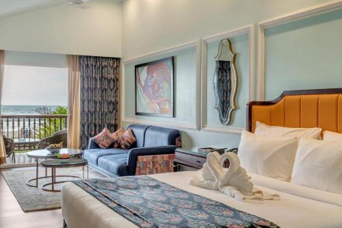 a hotel room with a bed and a living room at Mayfair On Sea, Morjim Beach, Goa in Morjim