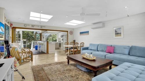 a living room with a blue couch and a table at Driftwood in Hawks Nest