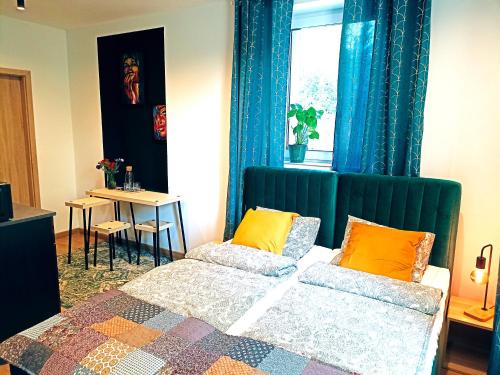 1 dormitorio con cama, mesa y ventana en Apartamenty Zakładowa, en Paczków