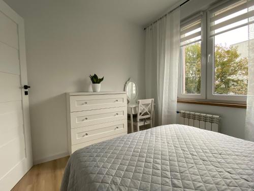 een slaapkamer met een bed, een dressoir en een raam bij Apartament Cynamon II in Sandomierz