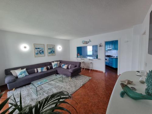 uma sala de estar com um sofá e uma mesa em Apartment on the sea em Puerto de la Madera