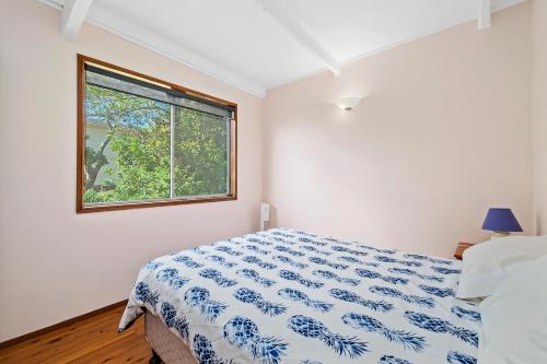 a bedroom with a bed and a window at Bally High, 20 Dulconghi Street in Crescent Head