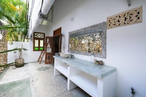 a bathroom with a counter with a sink on a wall at Villa Papaya Bingin in Uluwatu