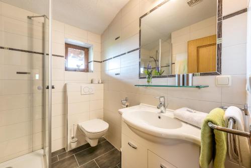 a bathroom with a sink and a toilet and a shower at Hinterburghof in Saalfelden am Steinernen Meer